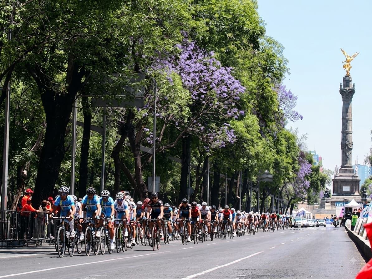 A peloton riding down Paseo de la Reforma toward the Ángel de la Independencia in Mexico City